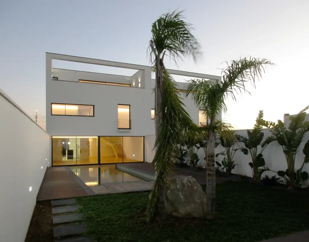 Jardim e piscina com deck junto às casas geminadas